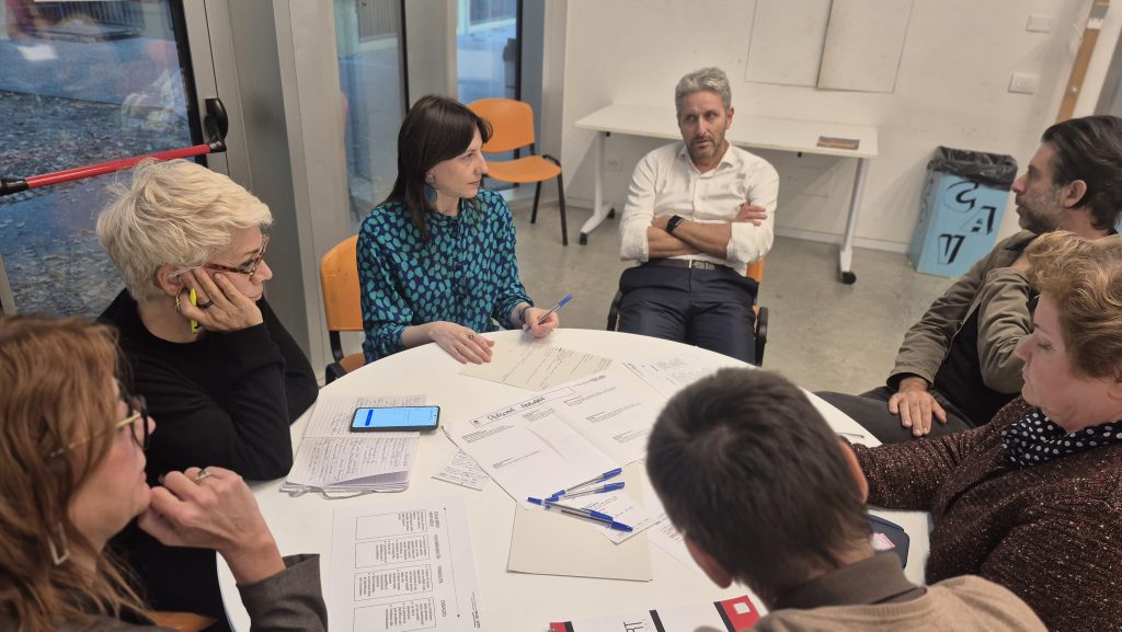 Partecipanti al laboratorio seduti a un tavolo nel Padiglione del Giaridno Joe Cassano