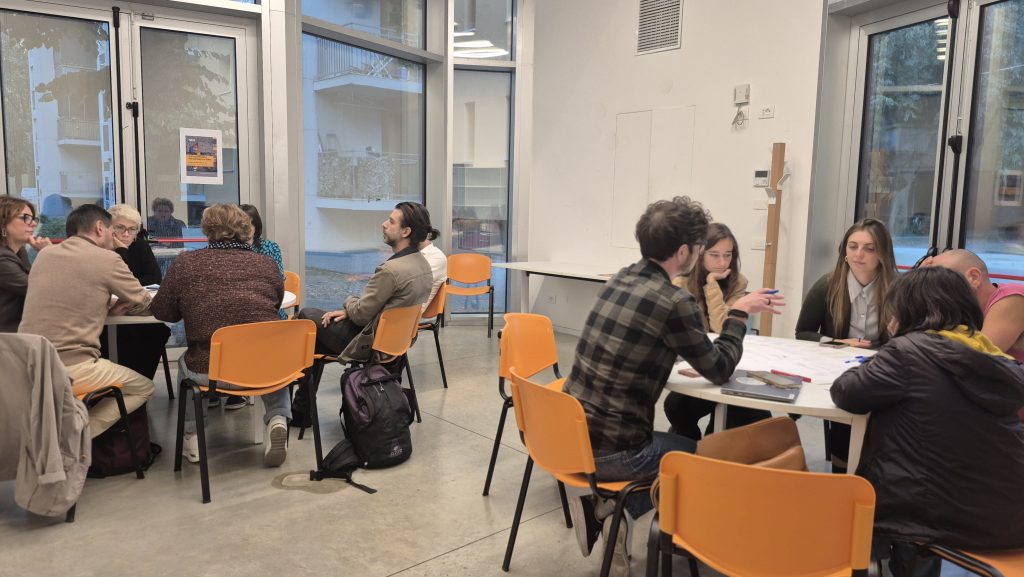Partecipanti al laboratorio seduti ai tavoli nel Padiglione del Giaridno Joe Cassano