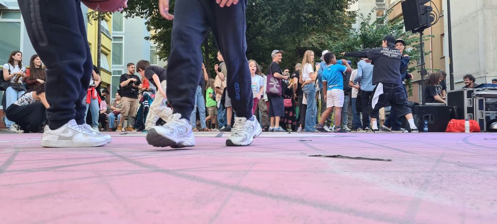 una folla di persone presenti all'intitolazione del giardino con sullo sfondo i palazzi delle popolarissime